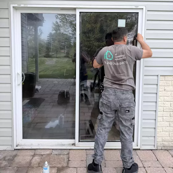 Person working on exterior sliding glass door installation