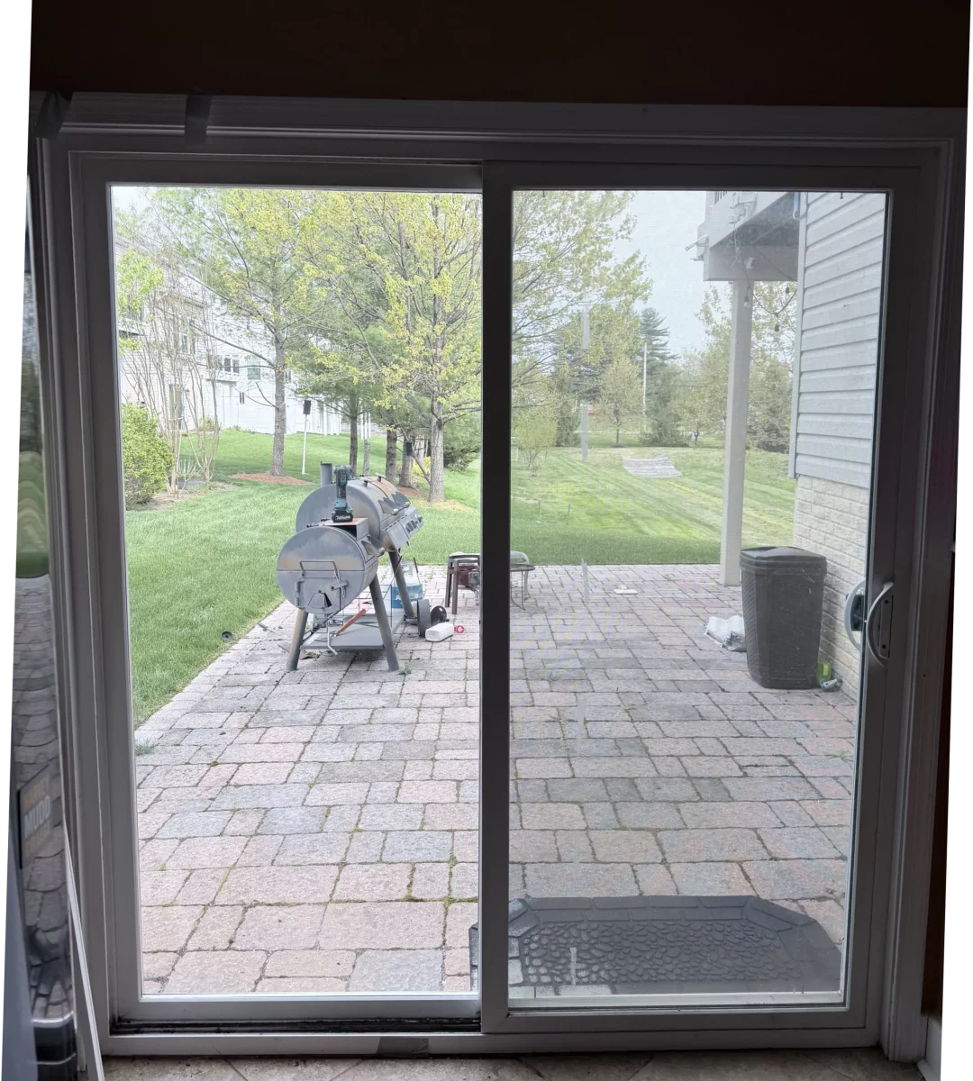 Sliding glass patio door with outdoor view and mat inside
