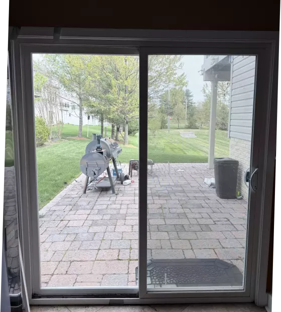 Sliding glass patio door with outdoor view and mat inside