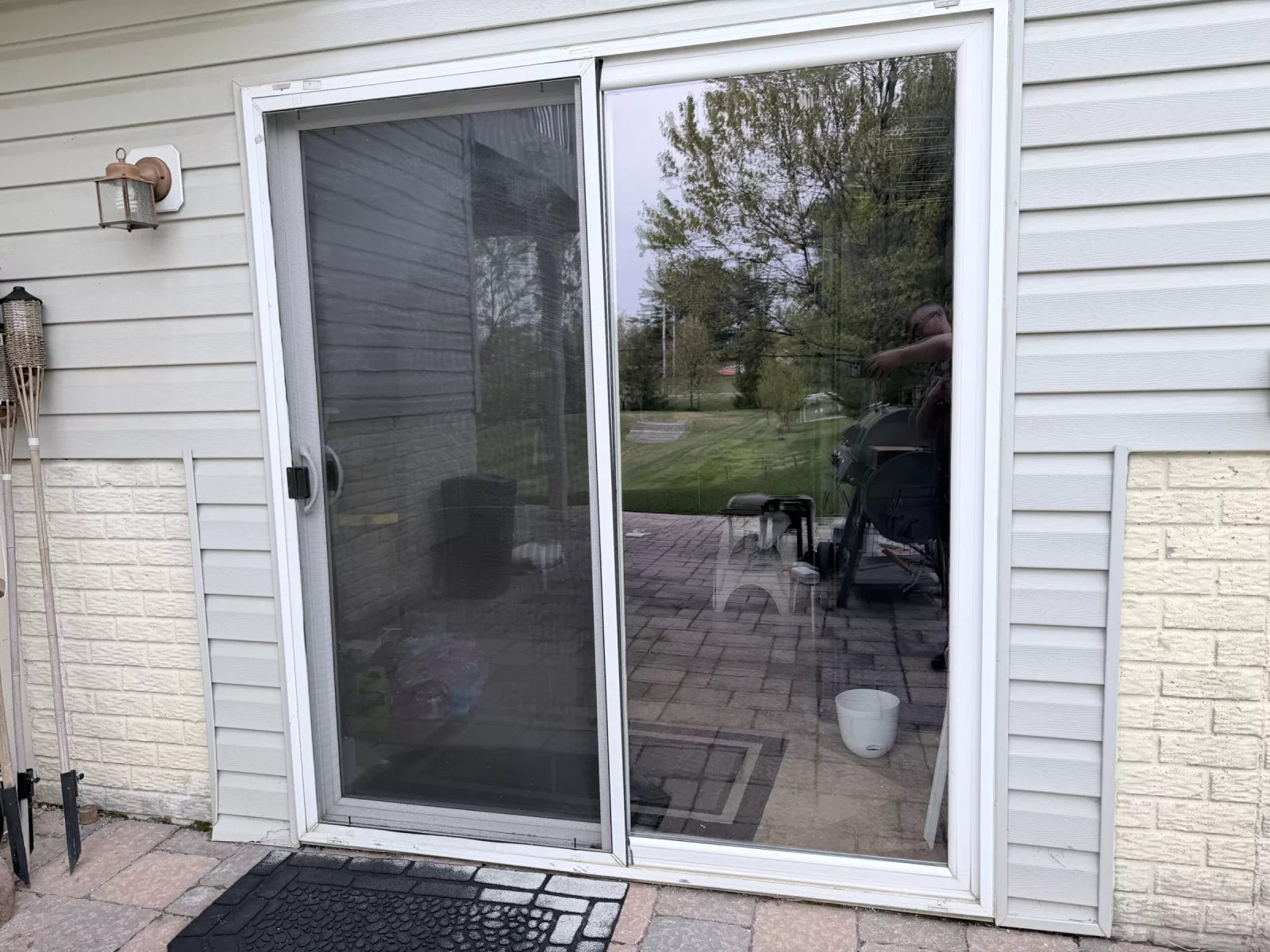 Exterior view of a residential sliding glass door with screen