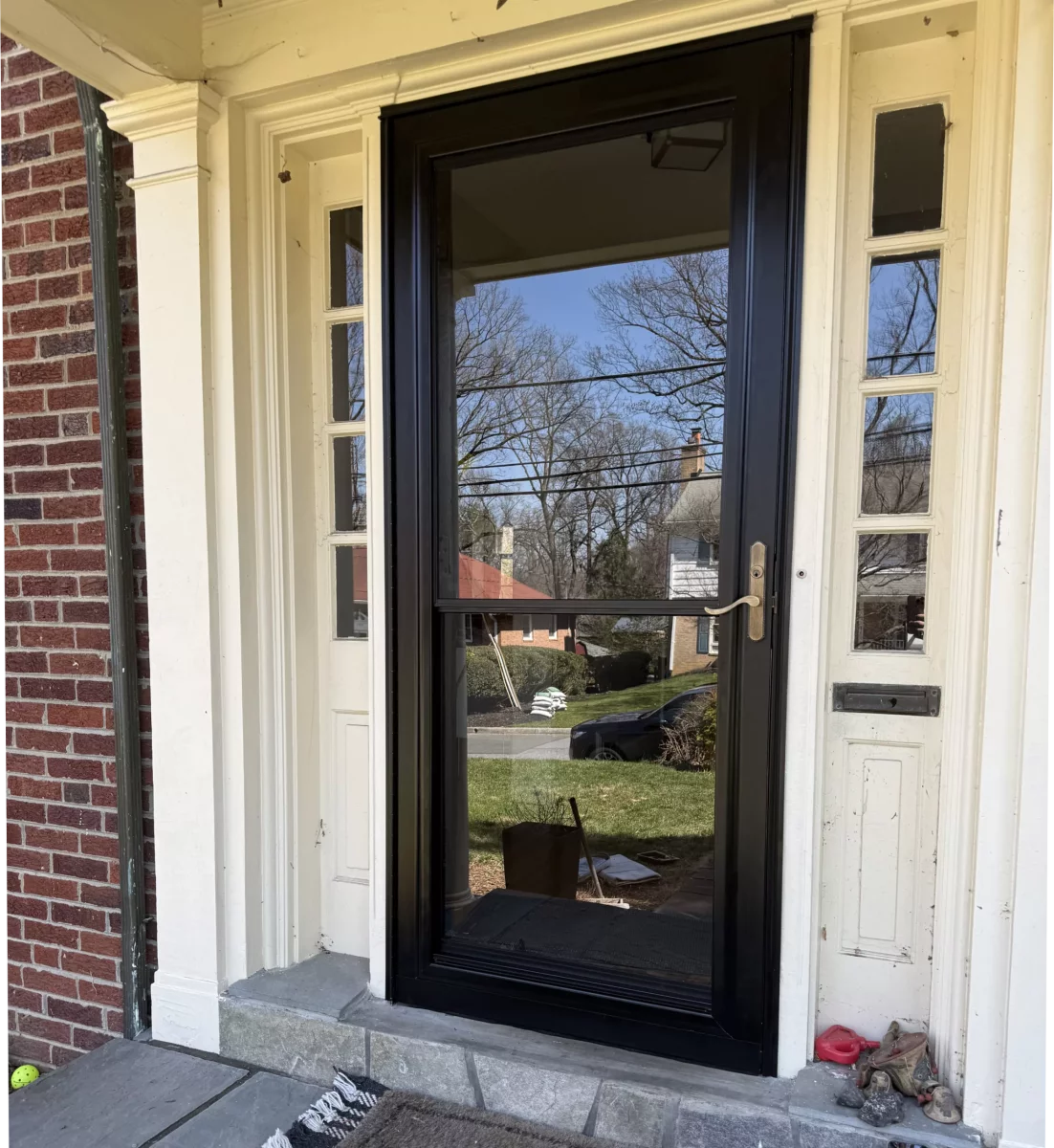 Black storm door installed at residential front entrance