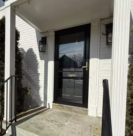 Exterior view of a house entry with a glass door and stone steps