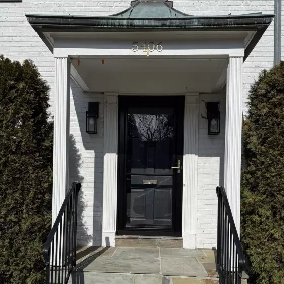 Exterior view of a front door with steps and railing