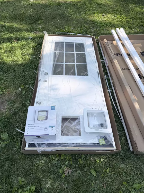 New exterior door with pet door and packaging on grass