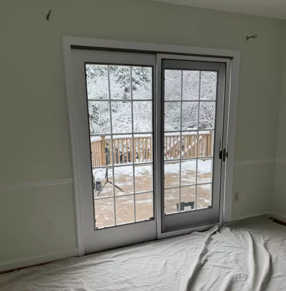 Patio door installation in progress with drop cloth on floor