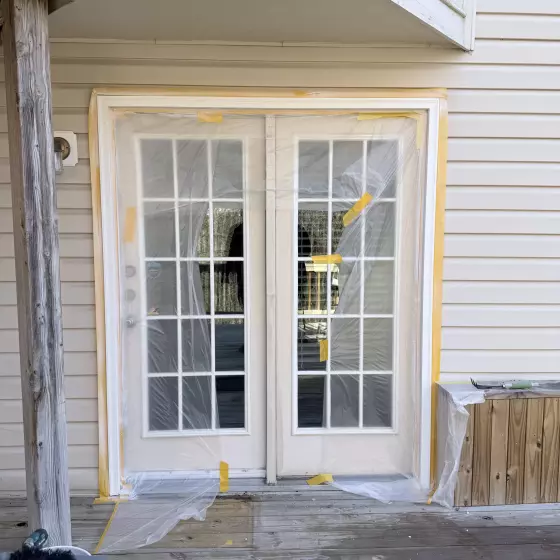French doors covered with protective film and tools on deck
