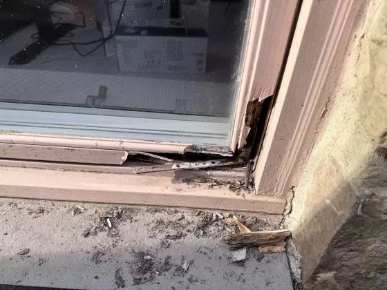 rotted window frame with debris and damaged wood visible
