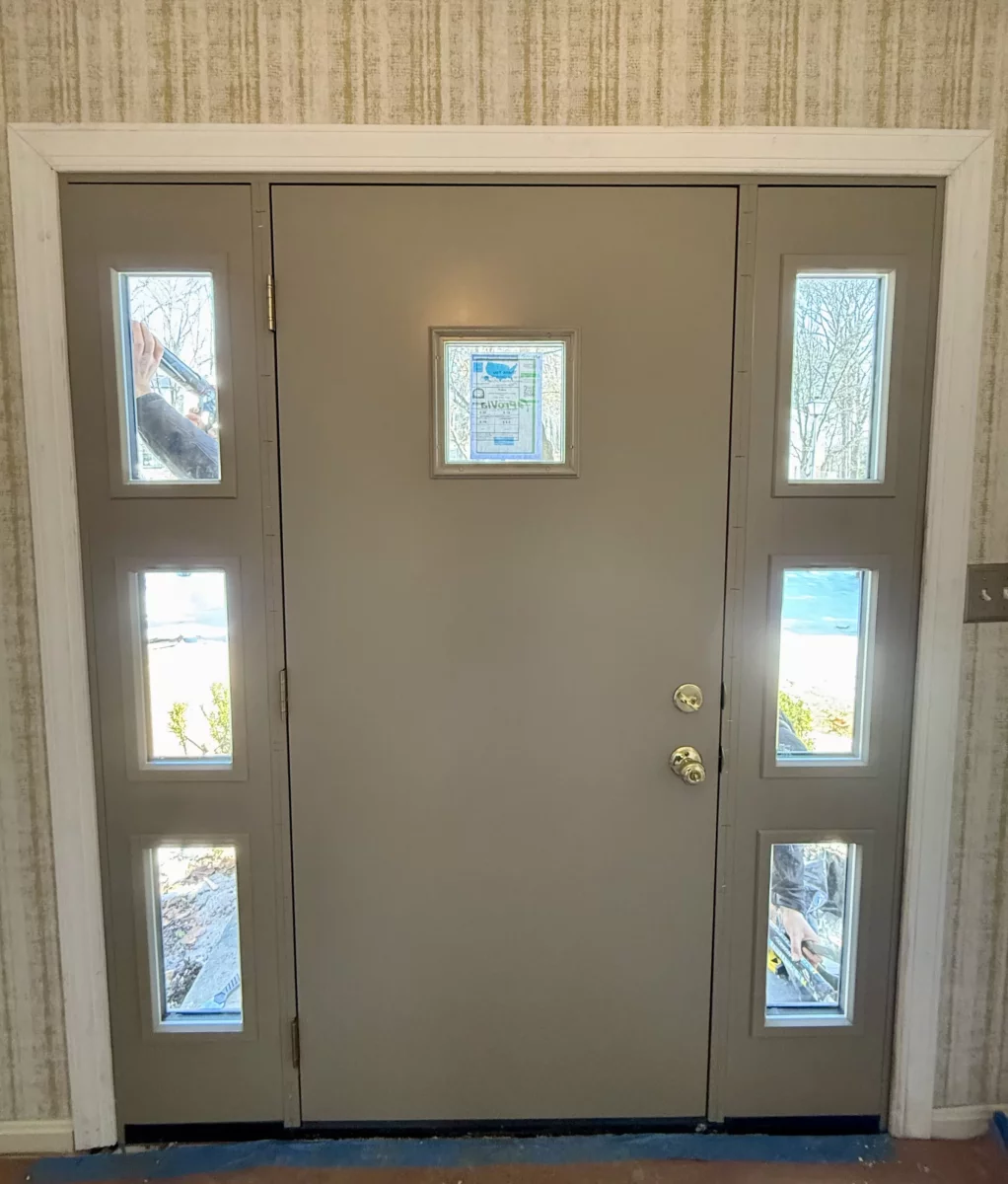 Entry door with sidelights being installed, viewed from inside