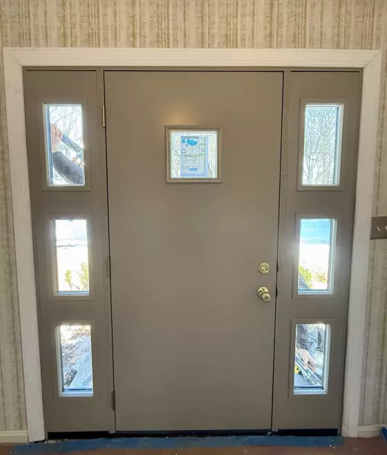Entry door with sidelights being installed, viewed from inside