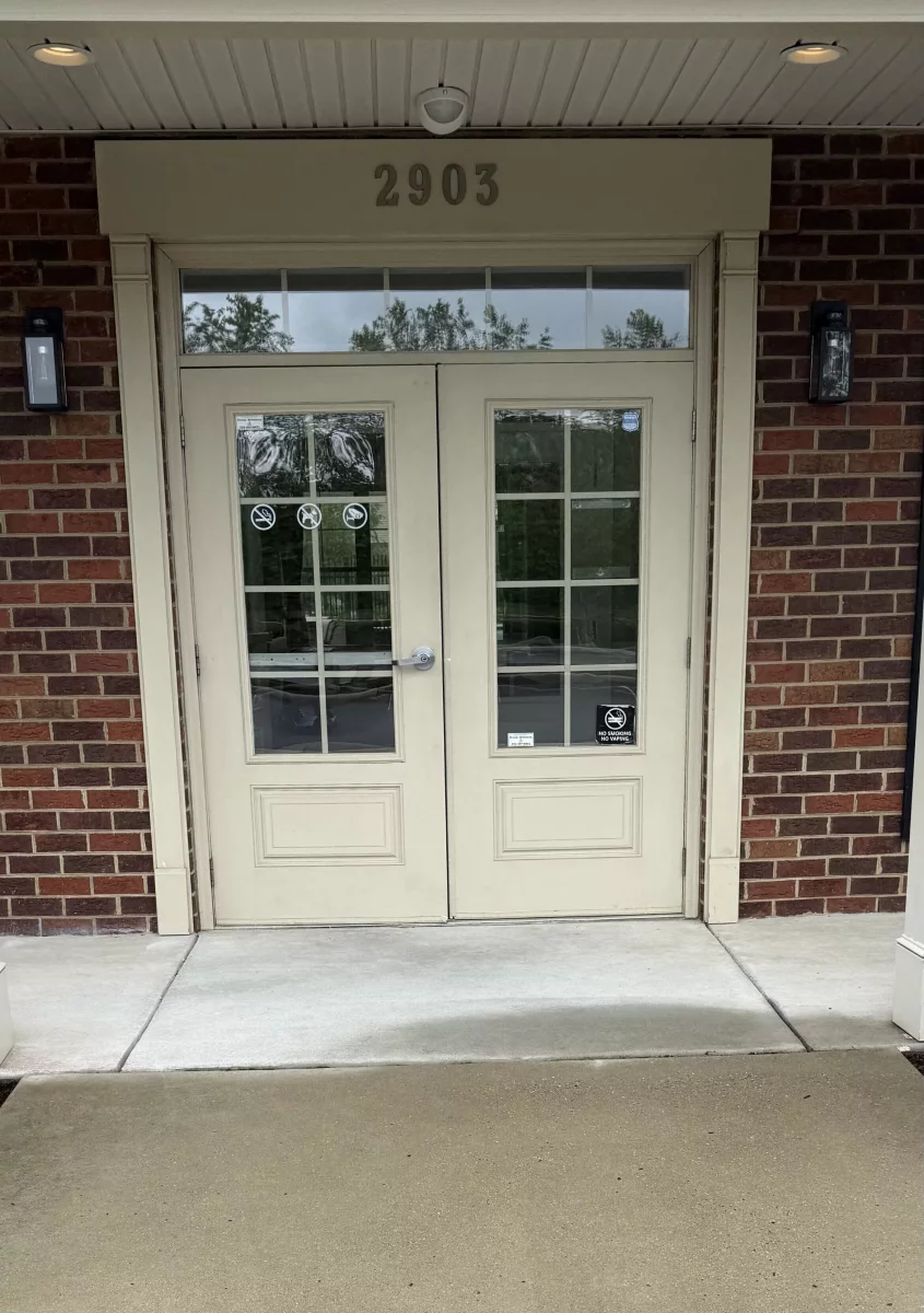 Double glass entry doors with brick exterior and handle