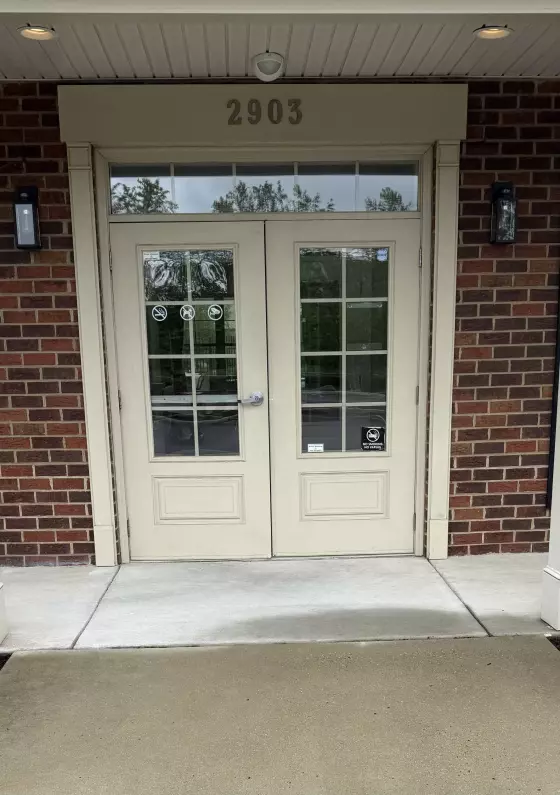 Double glass entry doors with brick exterior and handle