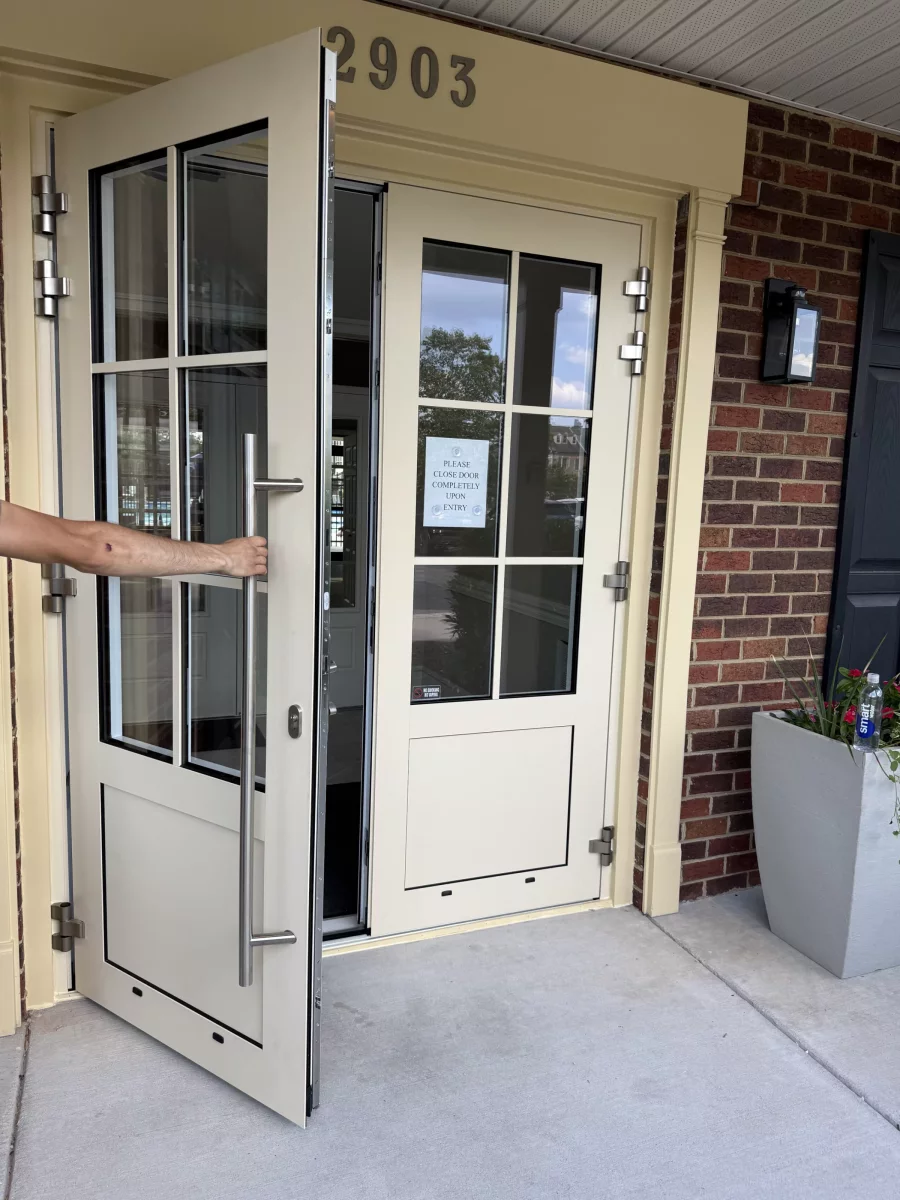 Glass entry door with handle and brick exterior wall