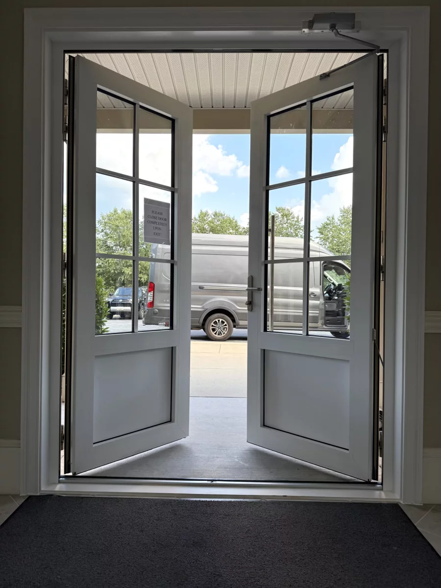 Double french doors open to exterior with van visible outside