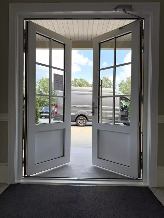 Double french doors open to exterior with van visible outside