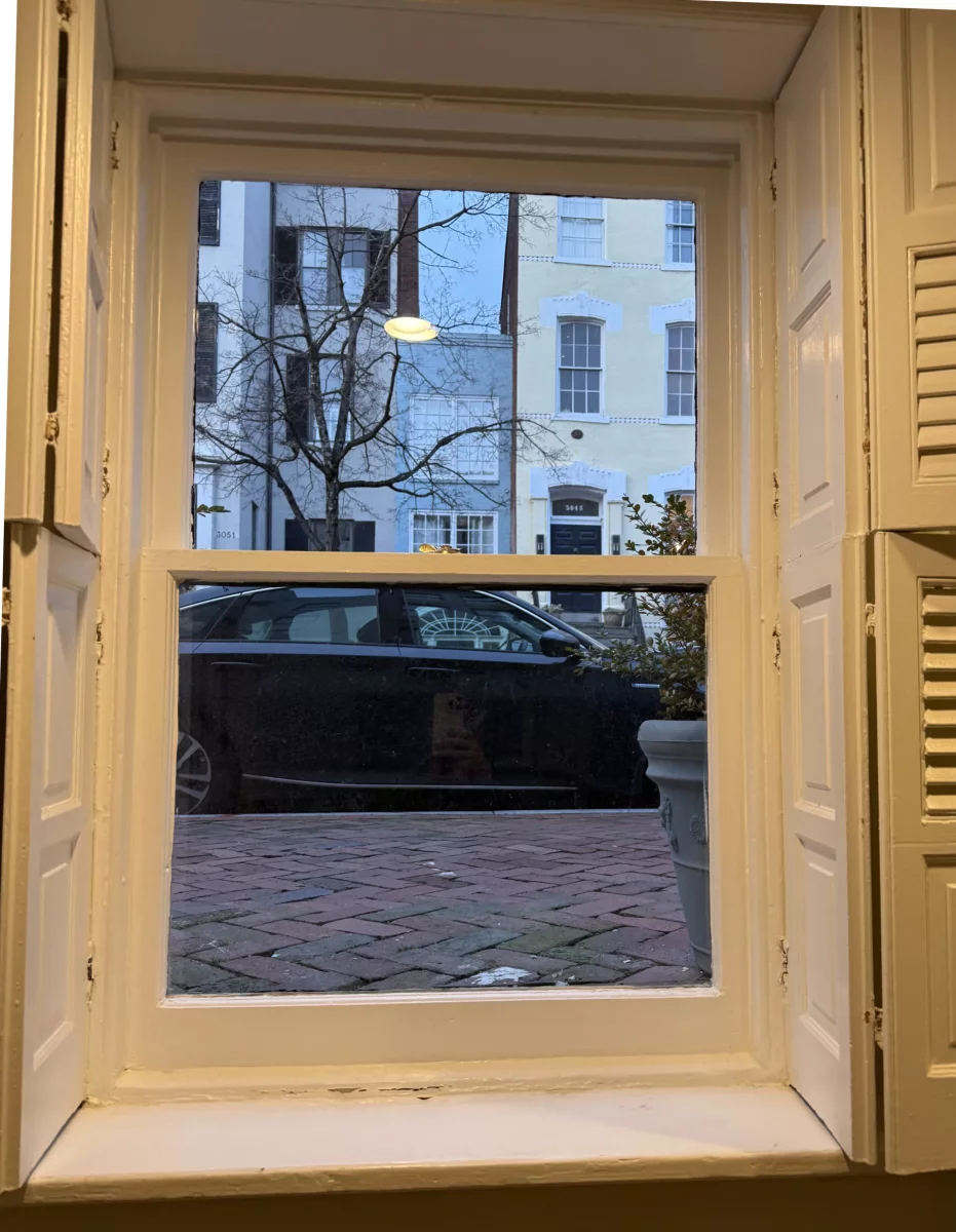 Interior view of a window with shutters and painted trim