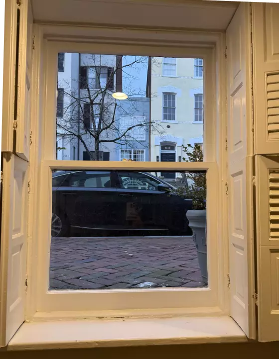 Interior view of a window with shutters and painted trim