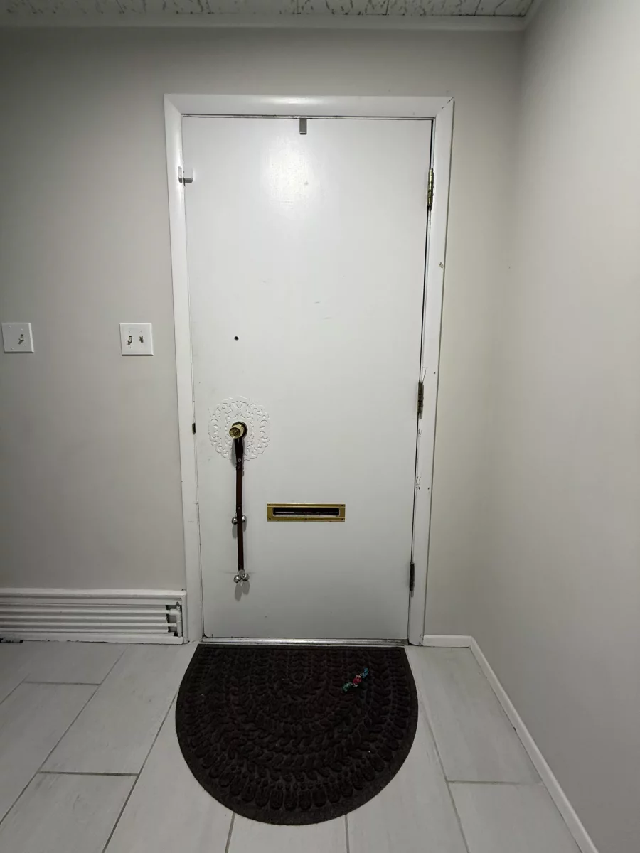 White interior door with mail slot and floor mat