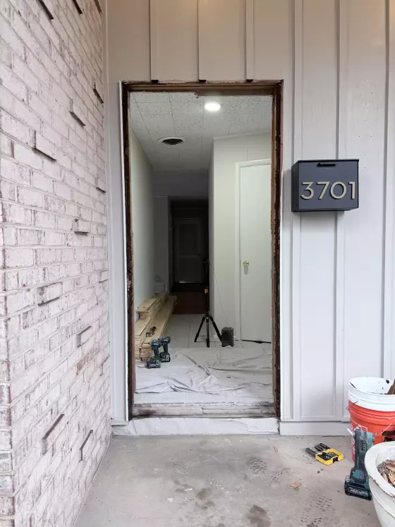 Front door opening under construction with tools and materials visible
