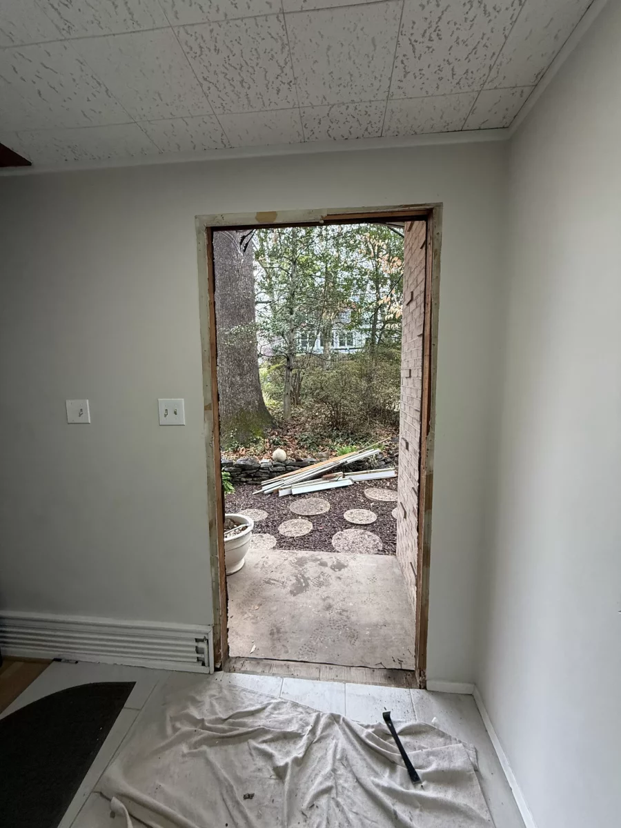 Interior view of doorway under construction with exposed frame and tools visible