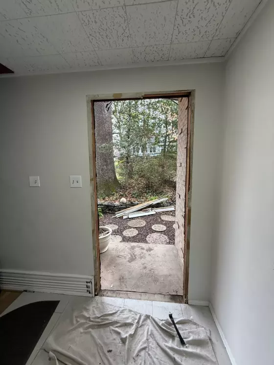 Interior view of doorway under construction with exposed frame and tools visible