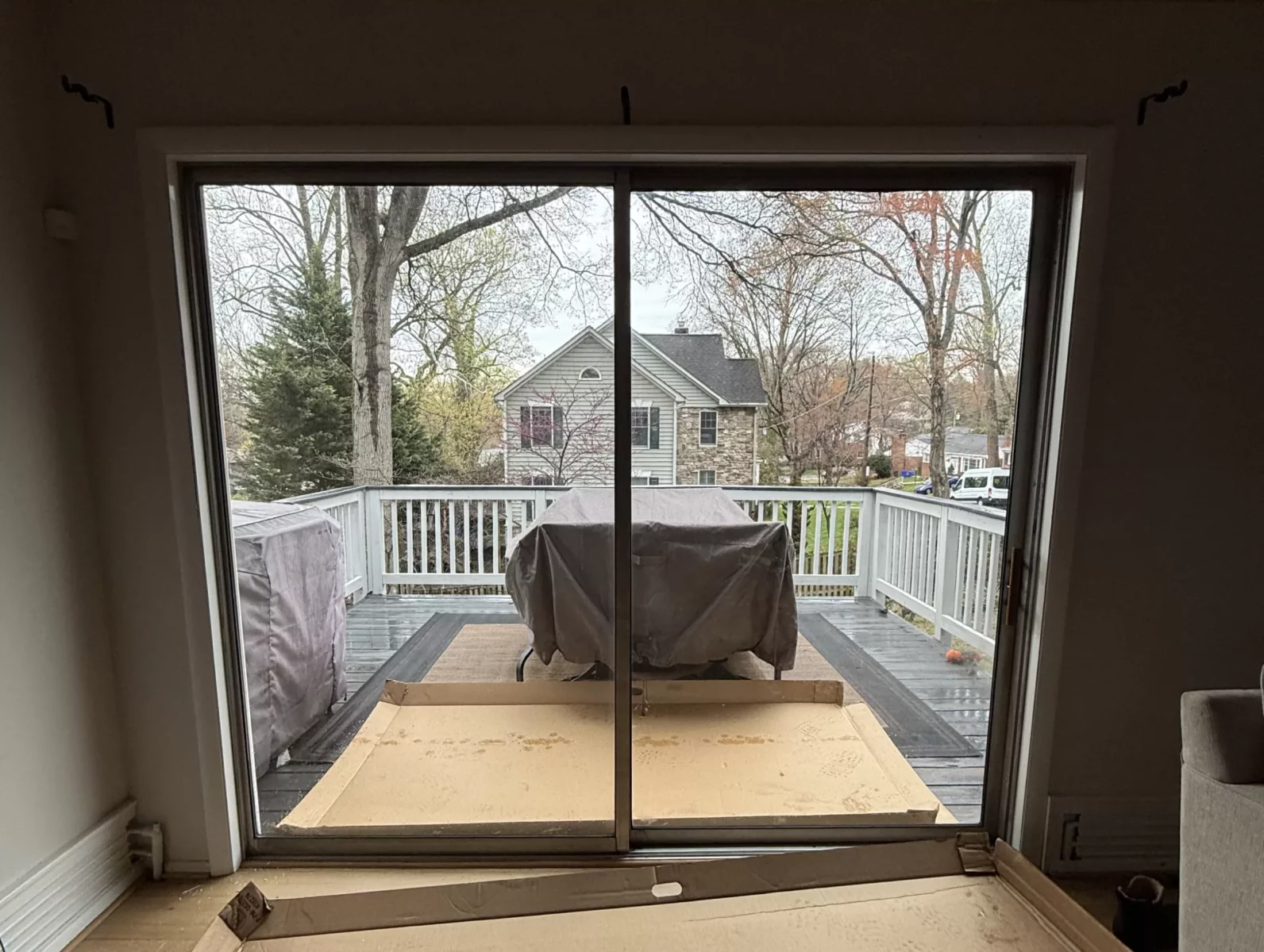 Sliding glass door with cardboard packaging on the floor inside a house