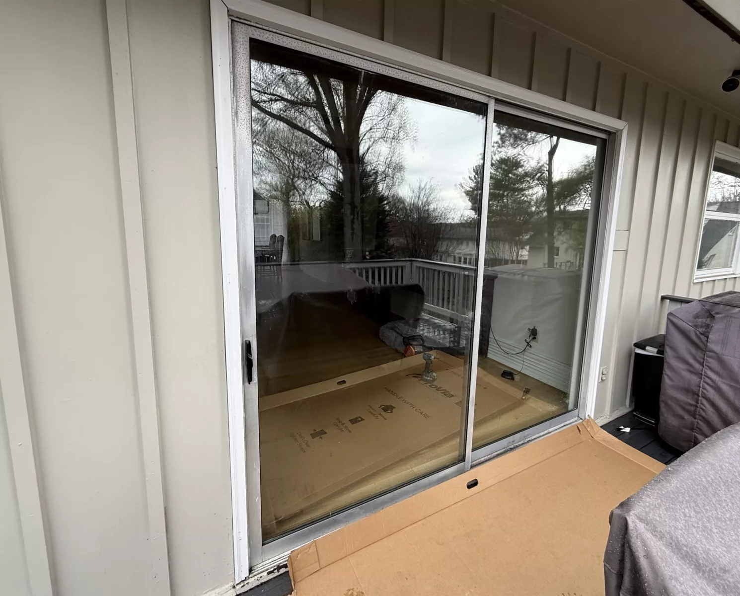 Exterior view of a sliding glass door with cardboard on the deck
