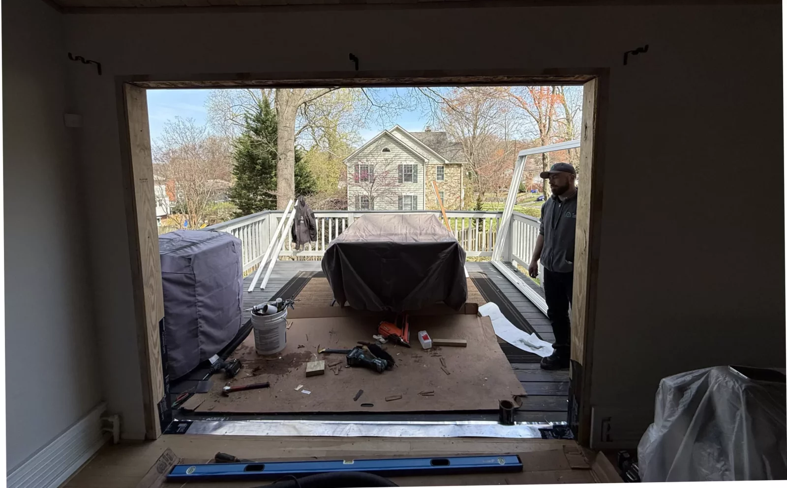 Door opening under construction with tools and worker on deck