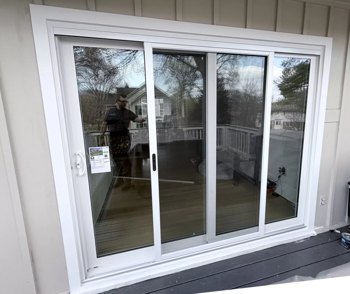 White sliding patio door installed on exterior deck with siding