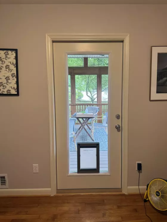 Interior view of a door with a built-in pet door and glass panel