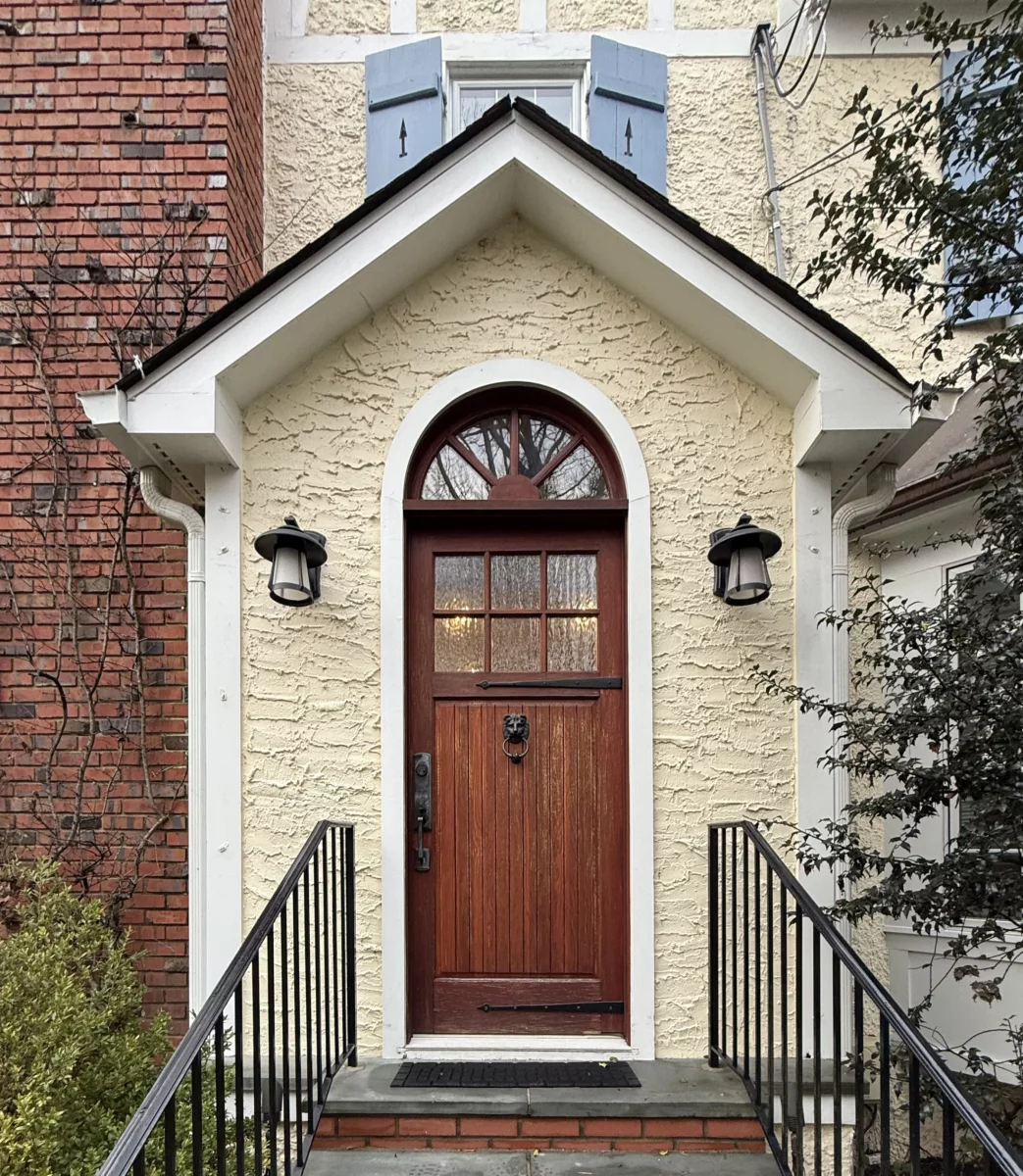 Front view of a residential entry door with steps and exterior lights