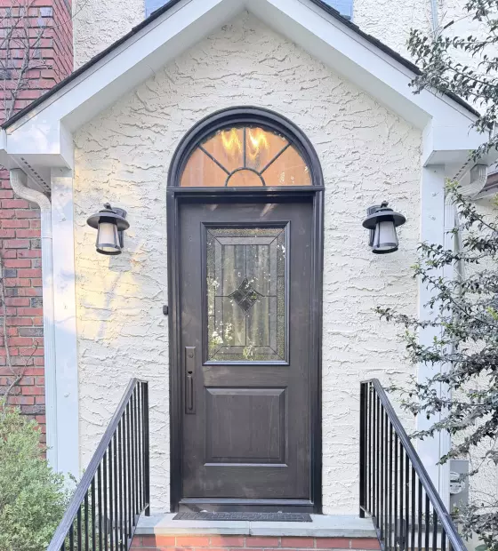 Front entry door with decorative glass on stucco exterior