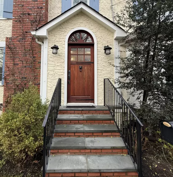 Front entry door with steps and stucco facade on residential house