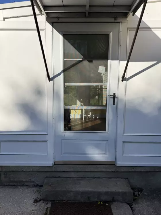 White exterior door with glass panel and metal handle