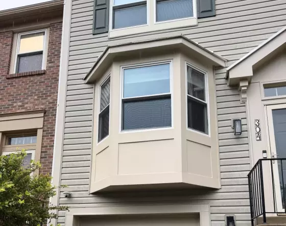Residential townhouse exterior with bay window and garage door