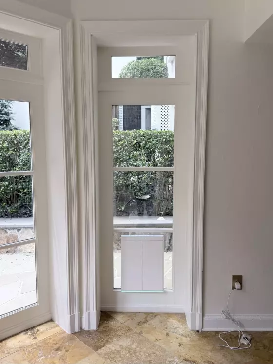Interior view of window with installed pet door and tile floor
