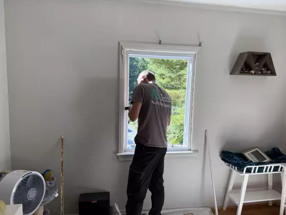 Person working on window installation inside a residential room