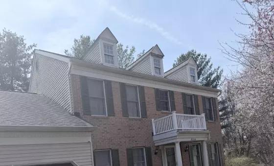 Front exterior of a brick house with multiple windows and garage