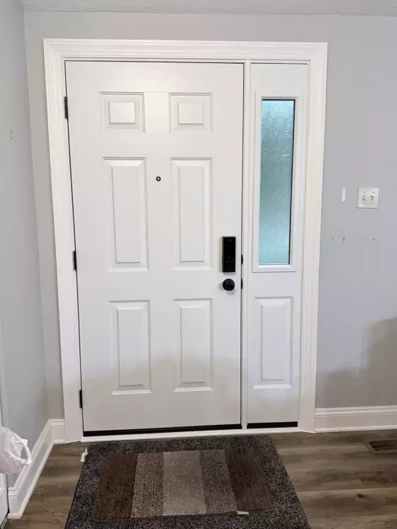 White entry door with side window and trim inside a home