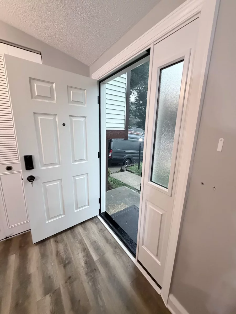 White entry door with glass panel and trim in a residential interior