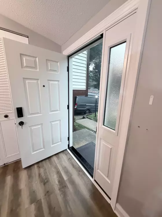 White entry door with glass panel and trim in a residential interior