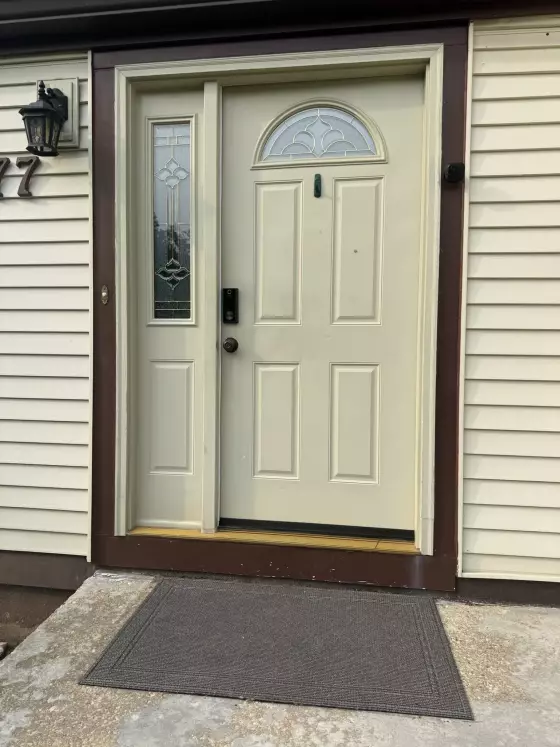 Before: Original front entry door and decorative glass sidelight before replacement in Columbia, MD.
