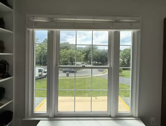 Interior view of a double-hung window with white trim and blinds