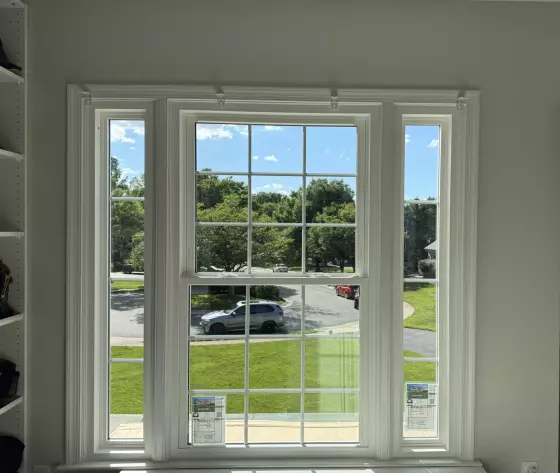 Completed energy-efficient window replacement in Rockville, MD, featuring a double-hung window with grids and two sidelites.