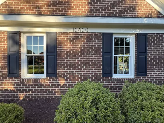 Full-frame double-hung window installation with colonial grids on a brick home in Rockville, MD.
