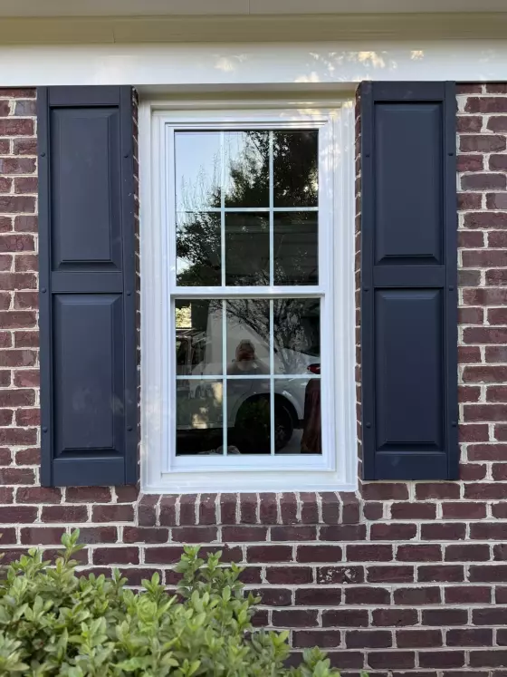 Full-frame double-hung window replacement with colonial grids on a brick home in Rockville, MD.