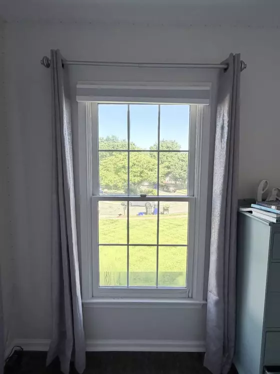 Interior view of a window with curtains and trim