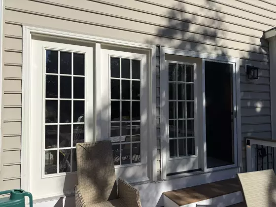 Exterior view of french doors and sliding door with white trim on a house