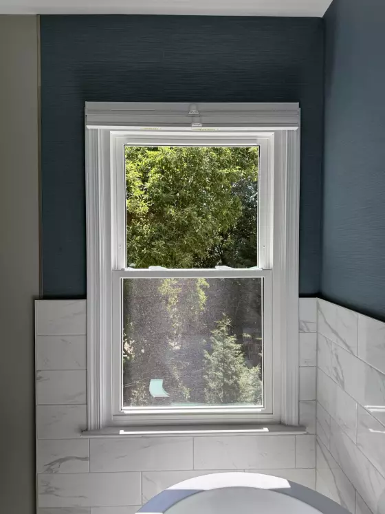 Energy-efficient double-hung window replacement in Rockville, MD, with grids and professionally finished interior trim.