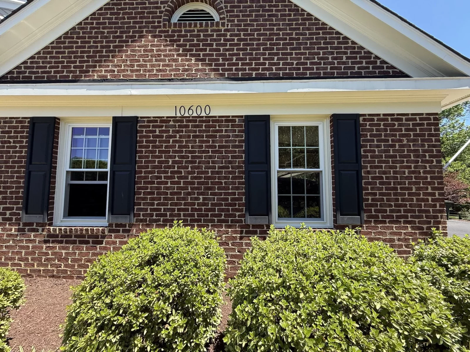 Energy-efficient double-hung replacement windows with colonial grids installed in a brick home in Rockville, MD.