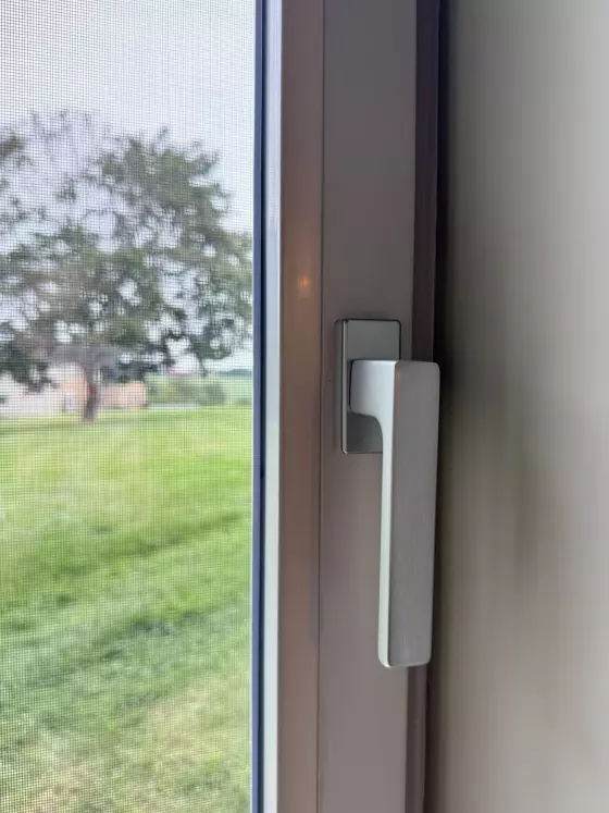 Close-up of a tilt and turn window handle and screen